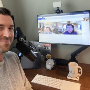 podcast host at mic with guests on video chat on monitor